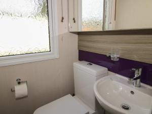 a bathroom with a toilet and a sink and a window at Swan in Leominster +42 photos