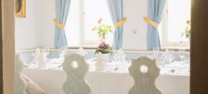 a dining room with a table with chairs and windows at Romantik Hotel Zum Klosterbräu in Neuburg an der Donau