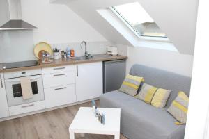 een woonkamer met een bank en een keuken bij L'appart T2 de la gare - Cambrai in Cambrai