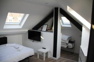 een kleine slaapkamer met een bed en twee ramen bij L'appart T2 de la gare - Cambrai in Cambrai