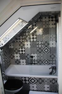 een badkamer met een zwart-witte tegelmuur bij L'appart T2 de la gare - Cambrai in Cambrai +3 foto's