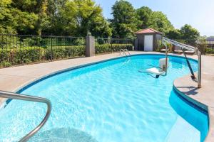 a swimming pool with blue water and a gazebo at La Quinta Inn by Wyndham Decatur Alabama in Decatur