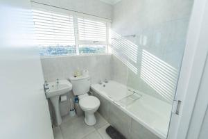 a bathroom with a toilet and a tub and a sink at The Heads Luxury 3 Bedroom in Port Elizabeth +28 photos