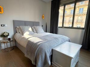 sypialnia z łóżkiem i dużym oknem w obiekcie L'appartement Matignon w Paryżu