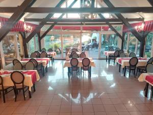 a dining room with tables and chairs and windows at Hotel Panorama in Mosonmagyaróvár +63 photos