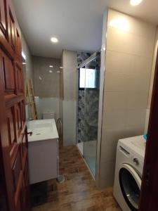 a bathroom with a shower and a washing machine at Casa Sauce in Puerto del Carmen