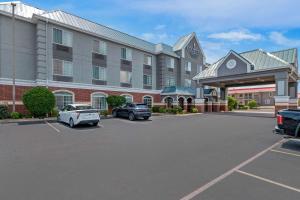a hotel with cars parked in a parking lot at Country Inn & Suites by Radisson, Hot Springs, AR in Hot Springs
