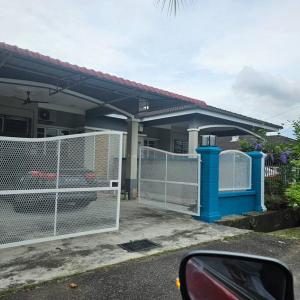 une clôture devant une maison avec un portail dans l'établissement Melaka Homestay Norelsya Bemban, à Bemban