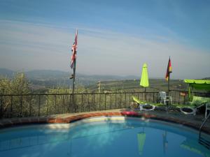 una piscina con dos banderas en una valla en Holiday Home Bel Panorama Due en Pelago