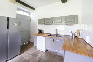 a kitchen with white cabinets and a stainless steel refrigerator at Maison Etxeparea in Ustaritz
