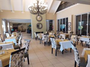 a restaurant with tables and chairs and a chandelier at Protea Hotel by Marriott Nelspruit in Nelspruit