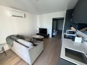 a living room with a couch and a table at Central CBD - parking - sleeps 4 in Canberra