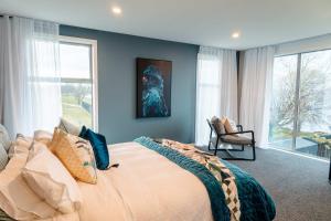 a bedroom with a large bed with a large window at Tiki's Tranquility in Rotorua +30 photos