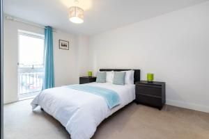 a white bedroom with a large bed and a window at Greenwich House in London