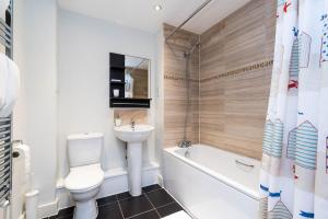 a bathroom with a toilet and a sink and a bath tub at Greenwich House in London