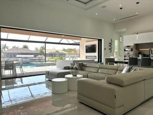 a living room with a large couch and a kitchen at Villa Twenty Two by CoralVilla - modern, pool & spa in Shell Point Village