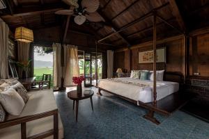 a bedroom with a bed and a couch in a room at ChezCao Rice Field Ecolodge Ninh Binh in Ninh Binh