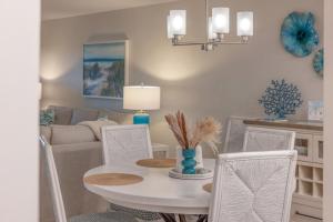 Un comedor con una mesa y sillas blancas. en Pelicans Roost 103 condo, en Sanibel