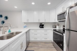 Una cocina blanca con fregadero y refrigerador. en Pelicans Roost 103 condo, en Sanibel 31 fotos más