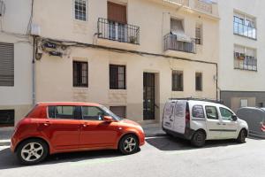 twee kleine auto's geparkeerd voor een gebouw bij Bonito piso cerca de park guell in Barcelona