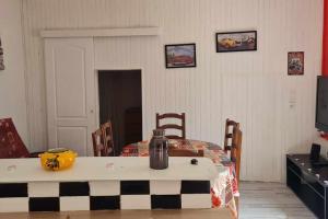 Maison vintage في Saint-Gondon: غرفة مع طاولة عليها زجاجة +صورتان