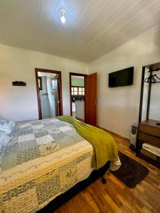 a bedroom with a bed and a flat screen tv at Pousada Vista Pedra Azul in Pedra Azul +36 photos
