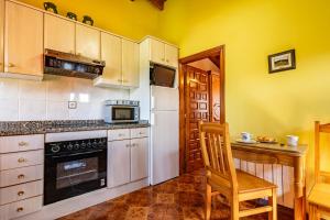 a kitchen with a white refrigerator and a wooden chair at La Casita de Heidi in Cangas de Onís