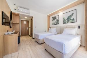 a hotel room with two beds and a desk at Sundia By Liberty Oludeniz in Oludeniz