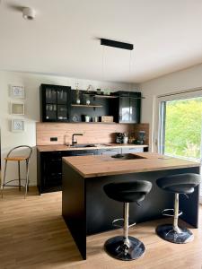 a kitchen with a large island with two bar stools at Wohnung am Wald in Geisa