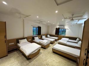 a room with four beds in it with windows at Hotel 777 in Akolia