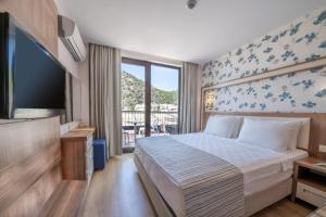 a hotel room with a bed and a television at Sundia By Liberty Oludeniz in Oludeniz
