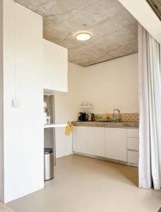 a kitchen with white cabinets and a ceiling at Cosy Studio 71 in Petite Case Noyale
