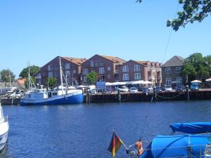 two boats are docked at a marina with houses at Kleines-Landhaus-Kopendorf in Bojendorf