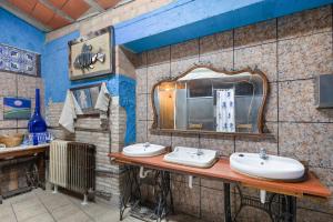 a bathroom with two sinks and a mirror at Casa refugi les Orenetes in Rocafort +25 photos