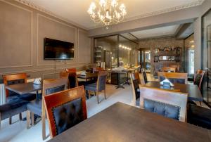 a restaurant with tables and chairs and a chandelier at Hotel Piazza Tbilisi in Tbilisi City
