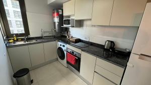 a kitchen with white cabinets and a washing machine at Guesthouse Park in Cordoba