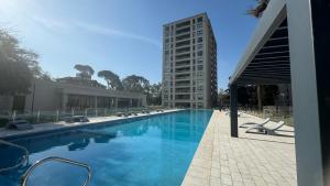 a large swimming pool next to a tall building at Guesthouse Park in Córdoba