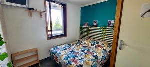 a small bedroom with a bed and a window at Charmant appartement au pied des pistes, avec une spacieuse terrasse ensoleillée in Gouaux-de-Larboust