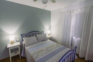 a blue bedroom with a bed and two night stands at Finca Campo Alegre in Utrera