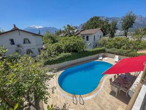 a swimming pool in front of a house with a red umbrella at Homekemer A in Kemer