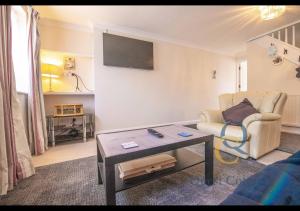 a living room with a couch and a table at Pittlesden Cottage - Sleeps 4 - Tenterden in Tenterden