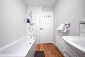 a white bathroom with a shower and a tub and a sink at Dunluce Park 2 - Portrush by the Sea in Portrush +27 photos