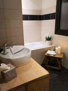 a bathroom with a sink and a tub and a mirror at ESTRELIAS - maison de vacances - Cauterets centre in Cauterets
