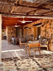 an outdoor patio with chairs and a stone wall at Casa en el Valle del Tietar CR-AV-01516 in Fresnedillas