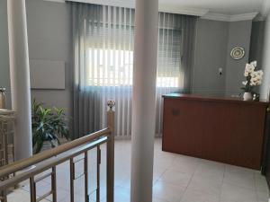 a room with a staircase and a desk andwindows at Pensión A&E in Manises