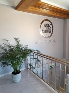 a sign on a wall above a staircase with a plant at Pensión A&E in Manises