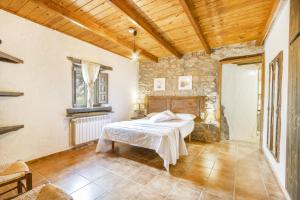 a bedroom with a bed and a stone wall at El Porxet in Navés +37 photos