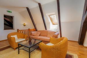 a living room with a couch and chairs and a table at Casa cu Cerb in Sighişoara