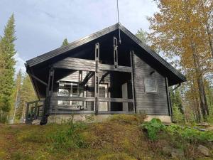 a house with a black roof on a hill at Syötekätkö in Syöte