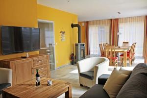 a living room with a couch and a flat screen tv at Ferienhaus Meinholdstraße mit eigener Sauna, Kamin, 4 Schlafzimmern ca 500m vom Ostseestrand in Ostseebad Koserow